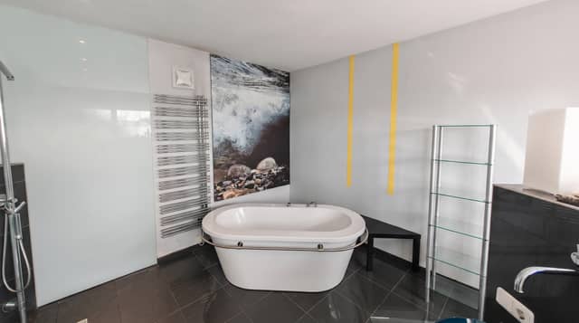 Freistehende Badewanne vor einer Glaswand